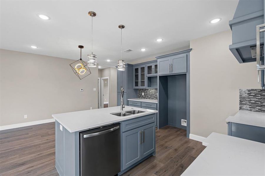 Kitchen featuring glass insert cabinets, dishwasher, pendant lighting, dark wood-style floors, and ventilation hood Kitchen featuring glass insert cabinets, dishwasher, pendant lighting, dark wood-style floors, and ventilation hood