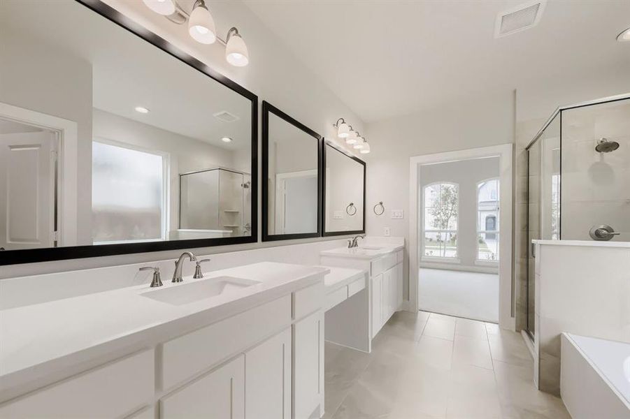 Double vanity featuring white cabinetry, integrated sinks, chrome fixtures, and large framed mirrors