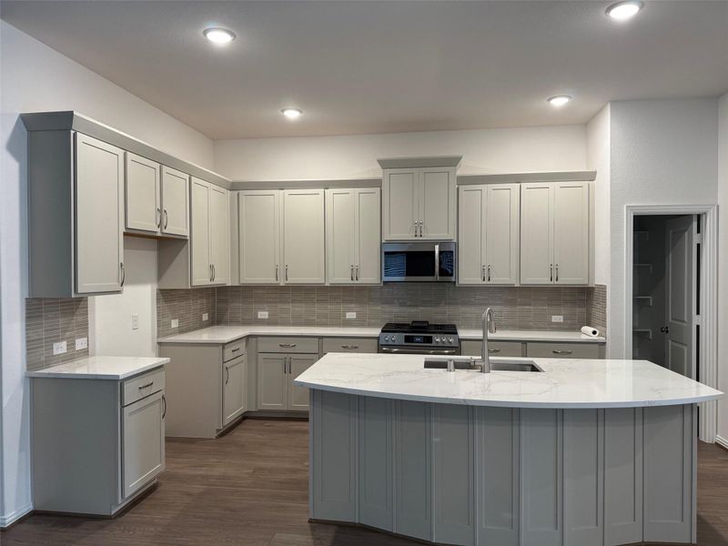 Stunning kitchen with omega stone countertops, stainless steel appliances, and custom cabinetry. Stunning kitchen with omega stone countertops, stainless steel appliances, and custom cabinetry.