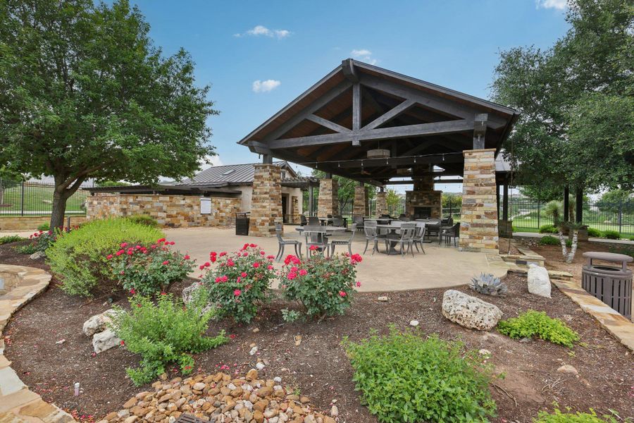 This outdoor amenity features a covered patio with exposed wood beams and stone pillars