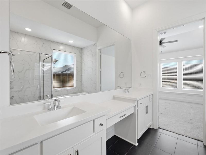 Primary bathroom featuring double vanity and a marble finish shower