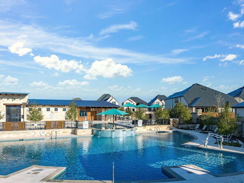 Community pool with a patio area, a residential view, and a hot tub Community pool with a patio area, a residential view, and a hot tub