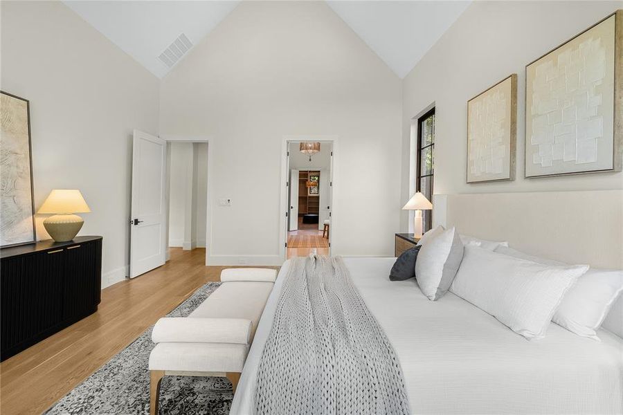 Vaulted ceilings define this interior space, featuring light wood-finish flooring and a neutral color palette