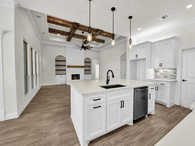 Kitchen with coffered ceiling, a sink, a fireplace, wood finish floors, and visible vents Kitchen with coffered ceiling, a sink, a fireplace, wood finish floors, and visible vents