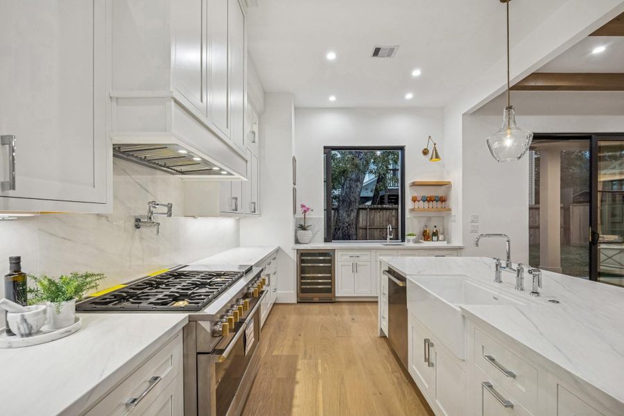 Another view of the Kitchen which also features all Inset Shaker Style Soft-Close Cabinets/Drawers, Slab Quartz Backsplash, Under-Cabinet Lighting, 4 GPM Wall Mounted Single Hole Pot Filler, 33" Farmhouse Single Basin Fireclay Kitchen Sink, Bridge Kitchen Faucet with Side Spray, InSinkErator Air Countertop Switch.