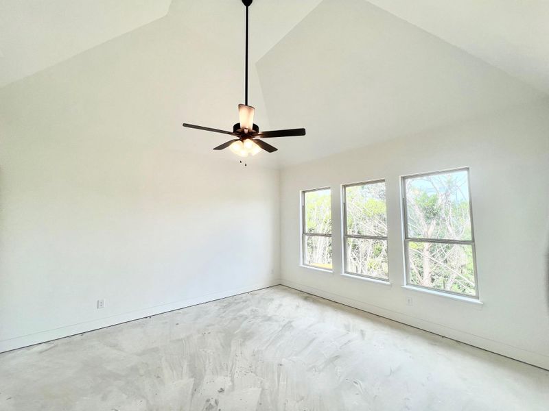 Spare room featuring high vaulted ceiling and concrete floors Spare room featuring high vaulted ceiling and concrete floors