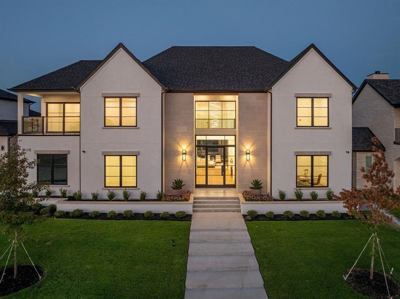 View of front facade with a balcony and a front lawn