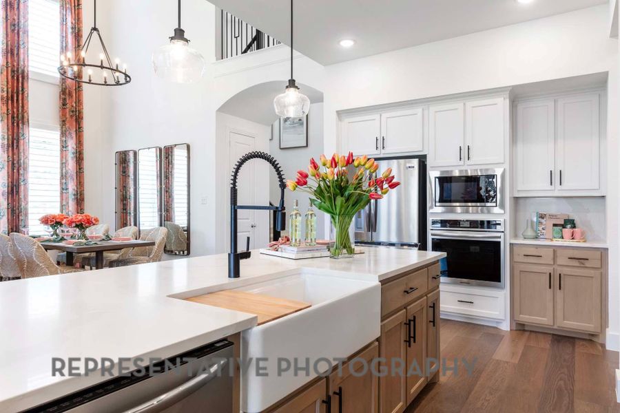 Kitchen featuring a sink, decorative light fixtures, light countertops, and appliances with stainless steel finishes Kitchen featuring a sink, decorative light fixtures, light countertops, and appliances with stainless steel finishes