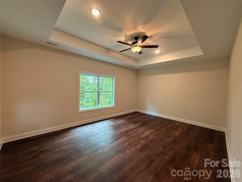 The primary bedroom is on the main floor and has a tray ceiling, double windows,...