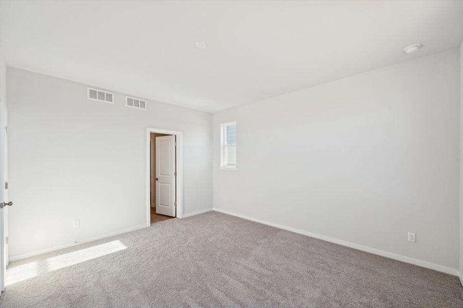A room with a carpet and a door.