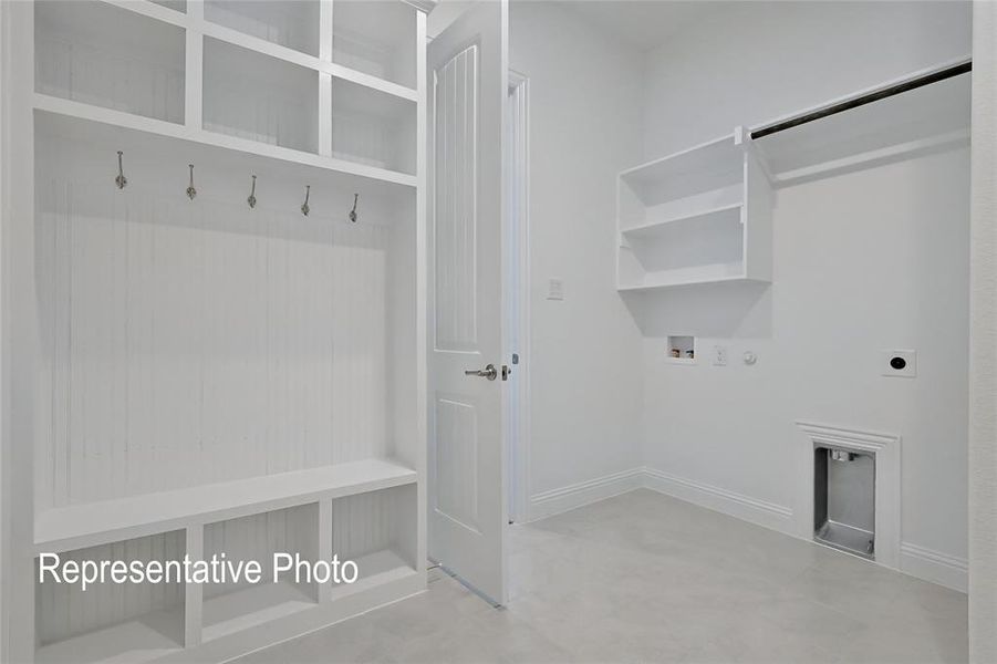 Utility space featuring a built-in mudroom bench with cubbies, overhead shelving, and wall hooks