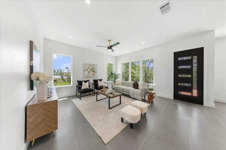 Tiled living area featuring a ceiling fan and recessed lighting Tiled living area featuring a ceiling fan and recessed lighting