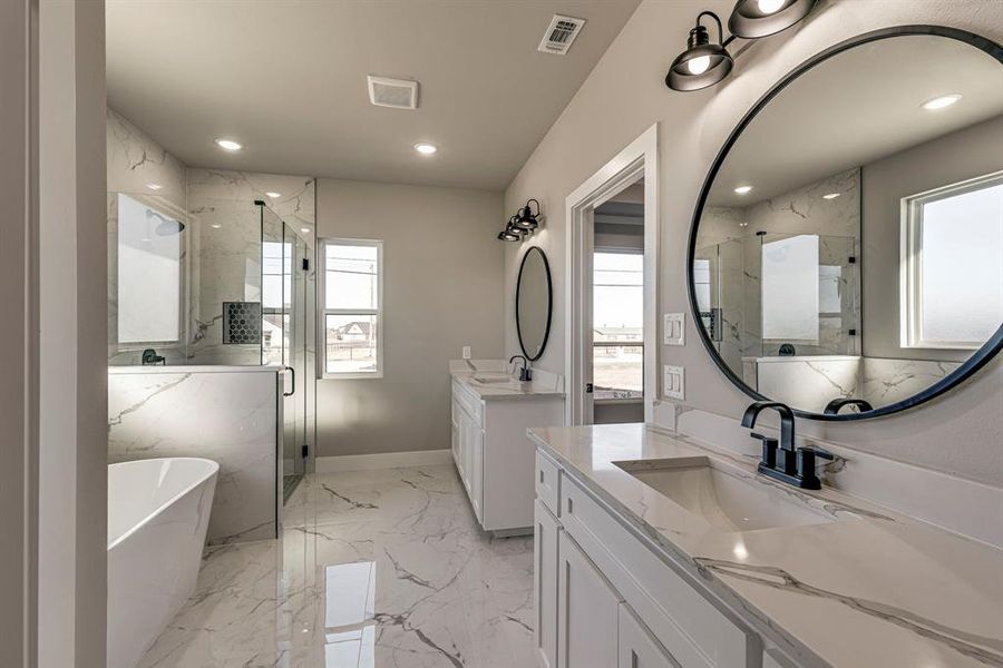 Bathroom with a marble finish shower, marble finish floor, a healthy amount of sunlight, and a sink