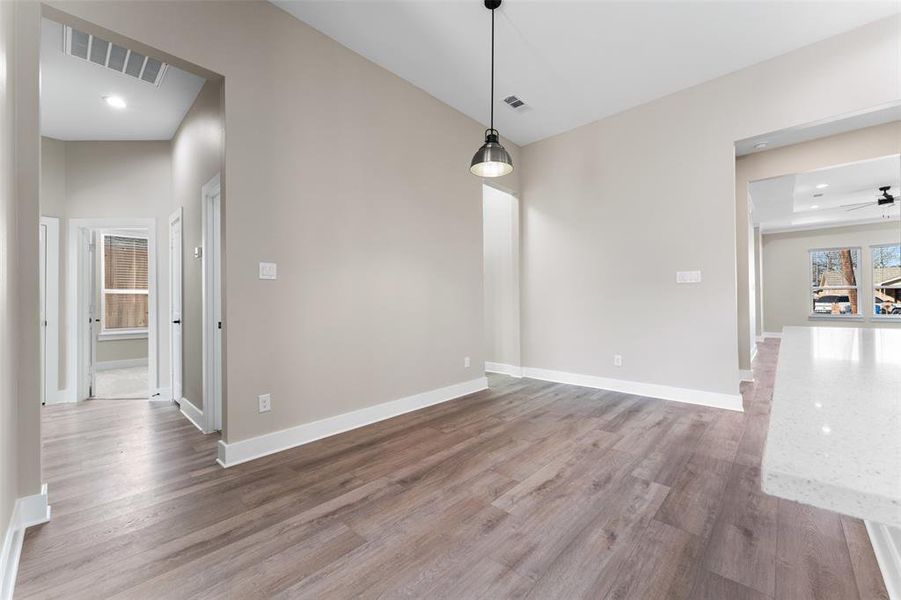 Unfurnished dining area with hardwood / wood-style floors and ceiling fan