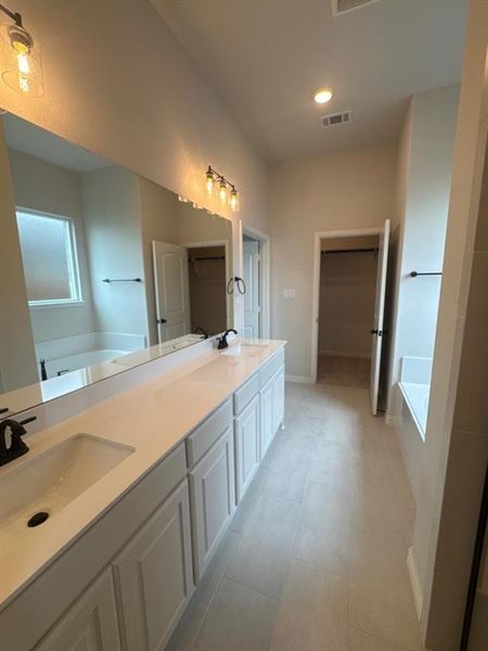 Double vanity with white cabinetry, integrated sinks, and black fixtures