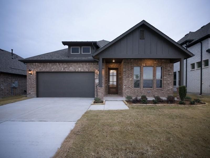 View of front facade featuring a garage and a front yard