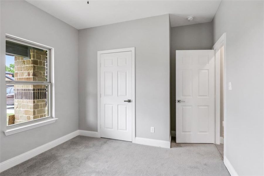 Unfurnished bedroom with light carpet