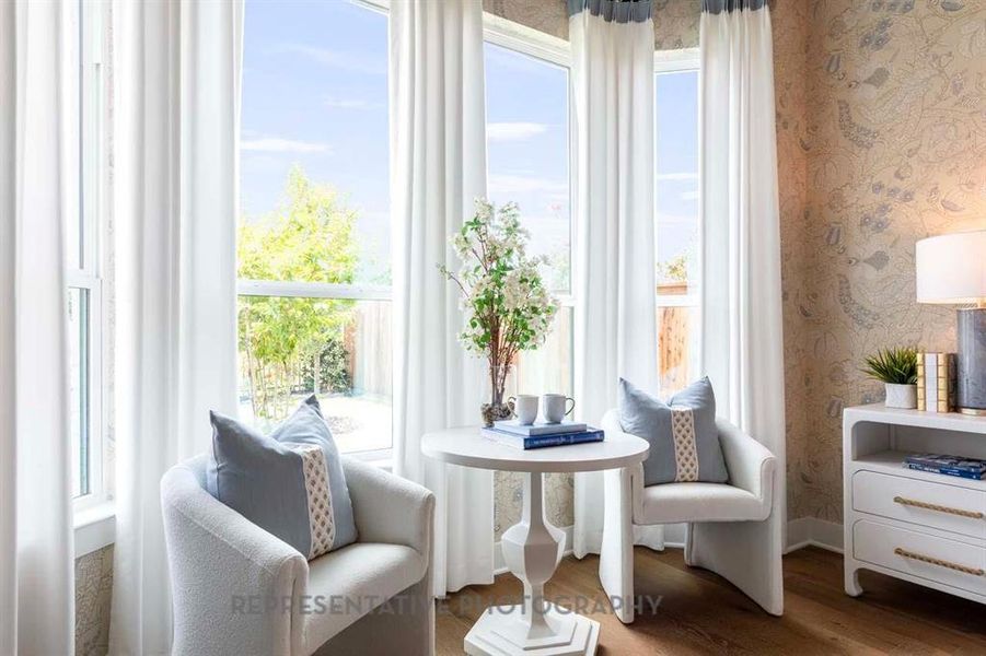 Sitting room featuring wallpapered walls, dark wood-style floors, and plenty of natural light Sitting room featuring wallpapered walls, dark wood-style floors, and plenty of natural light