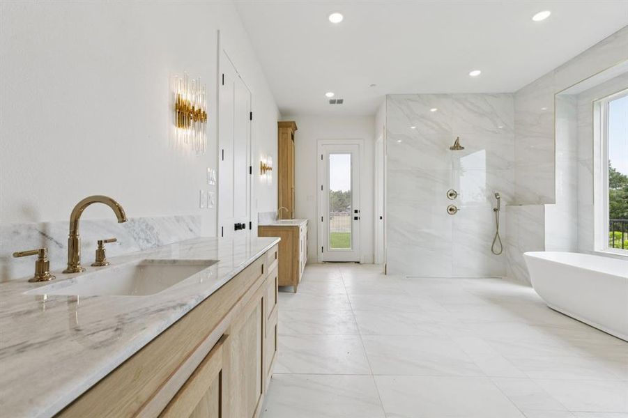 Incredible ensuite bath with separate vanities, a double shower, and soaking tub.