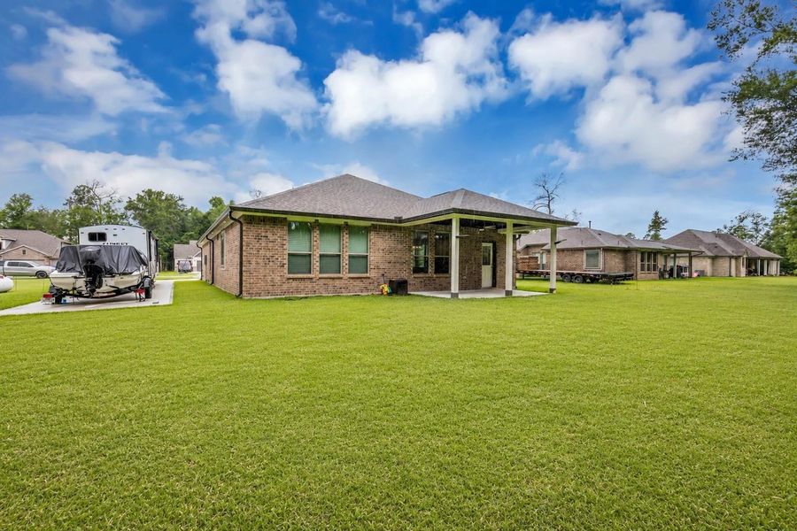 Backyard showing  spacious extended driveway and well kept lawn
