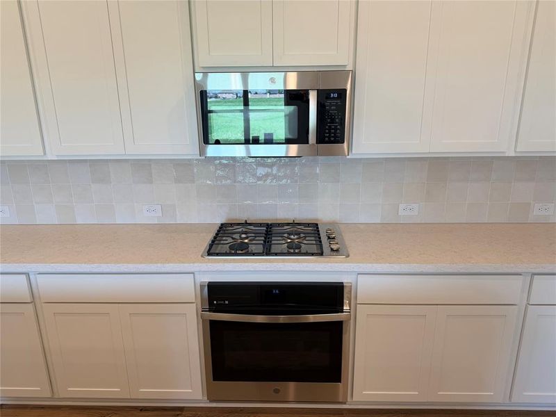Kitchen featuring white shaker-style cabinetry, a built-in stainless steel microwave, a gas cooktop, and a stainless steel wall oven