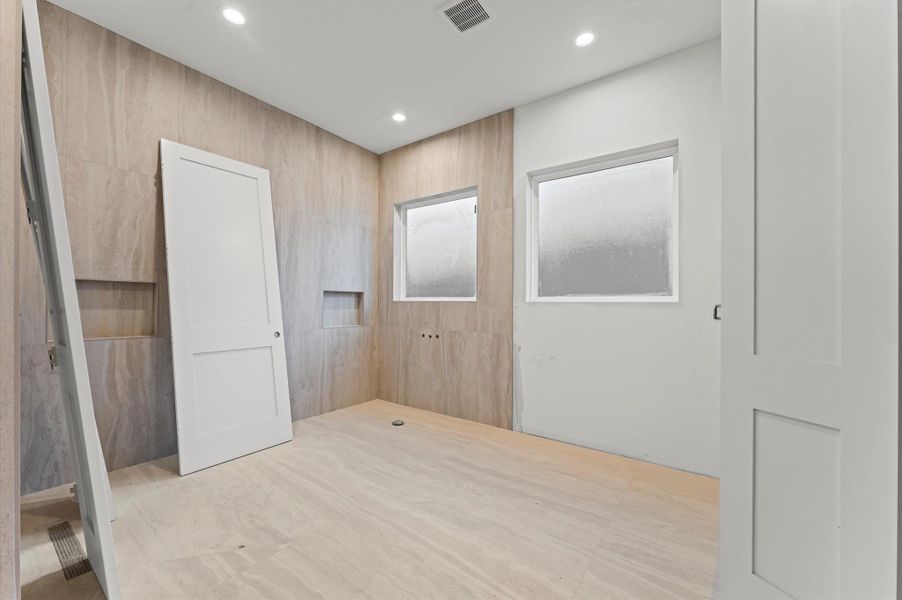 Primary bathroom with large shower and stand-alone soaking tub.