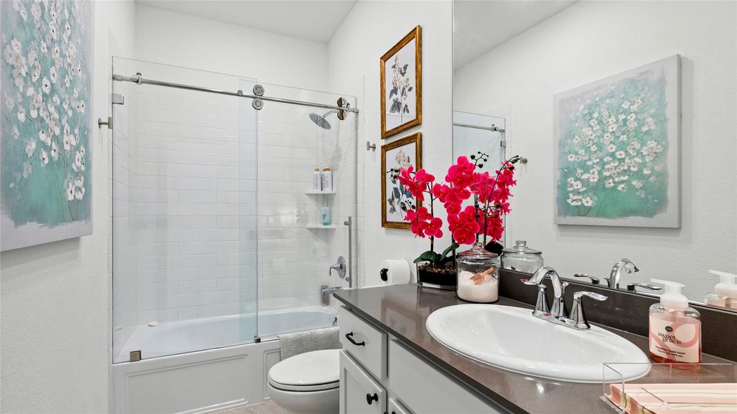 This charming secondary bathroom features an upgraded glass shower enclosure, elegant white tile, stylish fixtures, and upgraded cabinet pulls and handles for a polished, sophisticated finish. This charming secondary bathroom features an upgraded glass shower enclosure, elegant white tile, stylish fixtures, and upgraded cabinet pulls and handles for a polished, sophisticated finish.