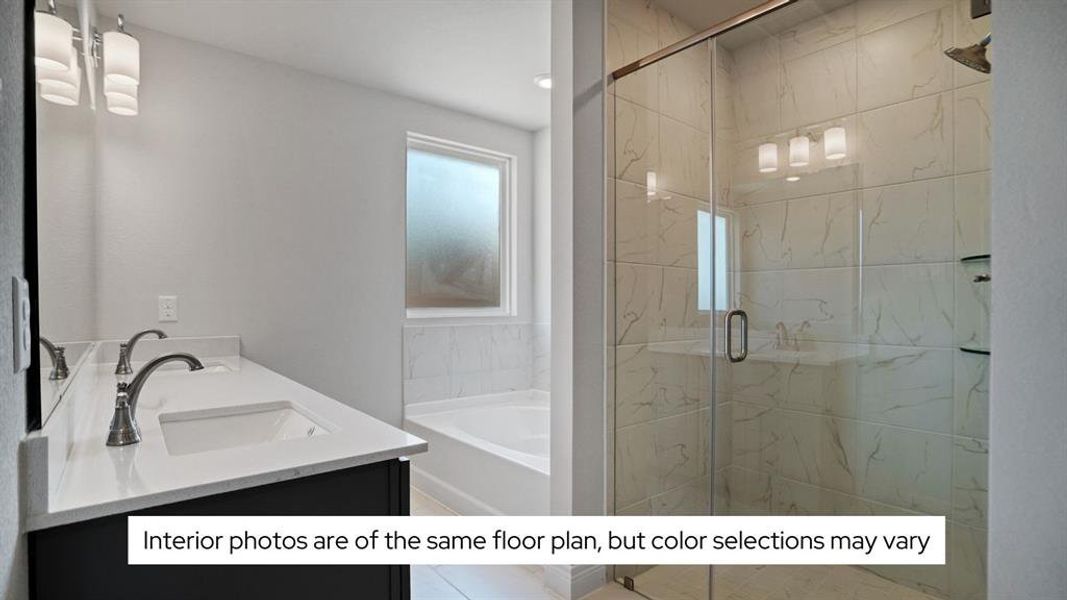 The primary bath features double sinks in the vanity, a large soaking tub, and a separate shower that is tiled to the ceiling.