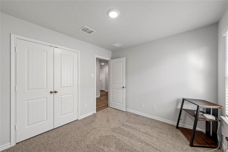 Unfurnished bedroom with carpet flooring, a closet, and multiple windows
