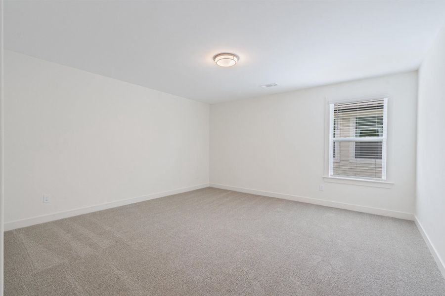 Spare room featuring light carpet and baseboards