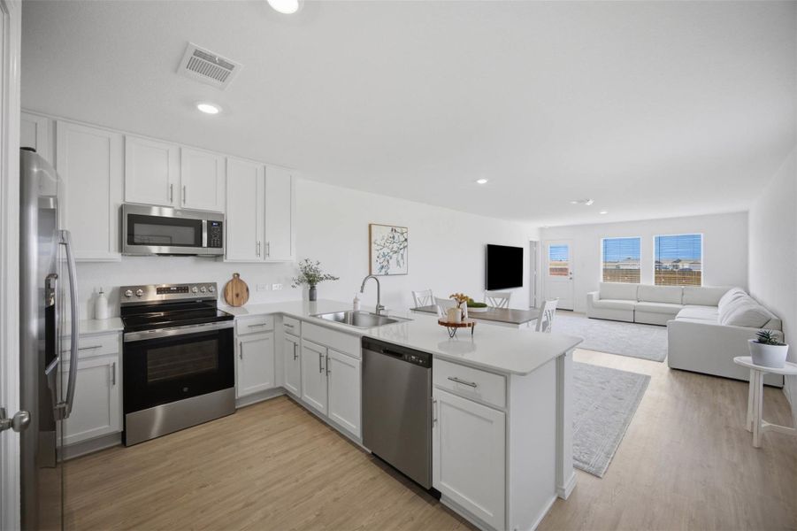 An open floor plan seamlessly connects the kitchen to the bright living areas.