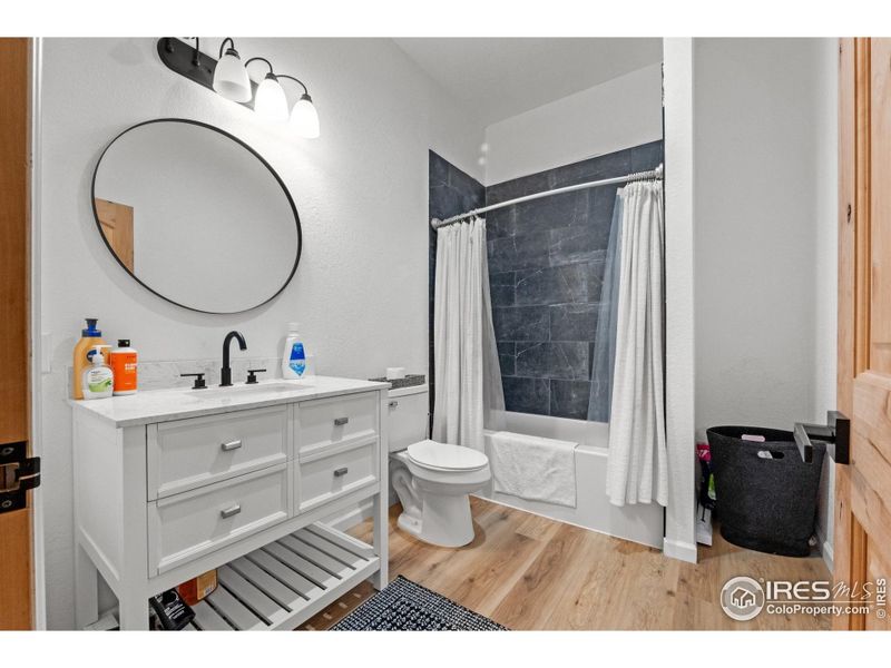 Convenient full bathroom designed for easy access in this split-bedroom layout features modern finishes and a clean, functional design
