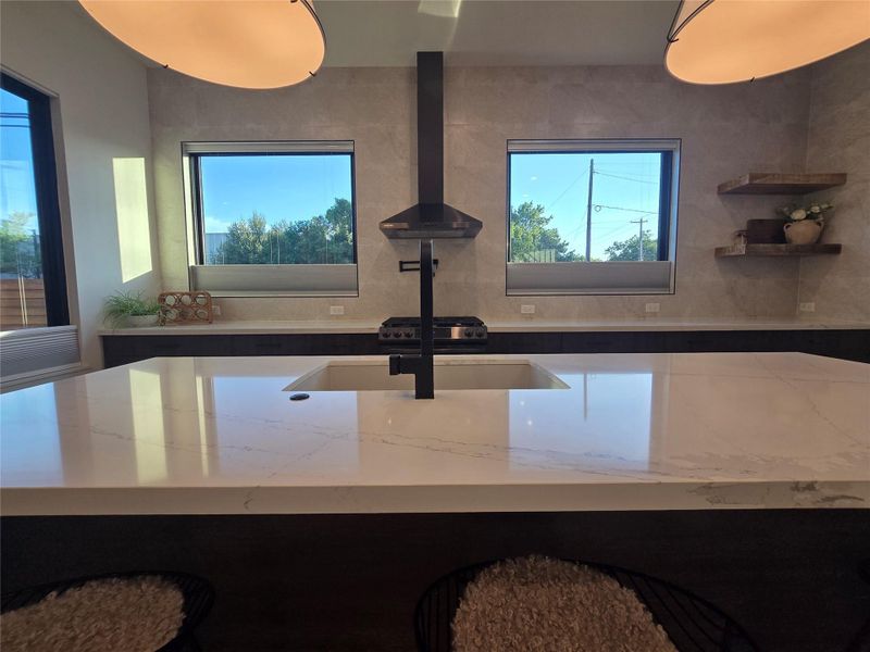 Clean architectural lines define this modern kitchen anchored by a substantial stone island.