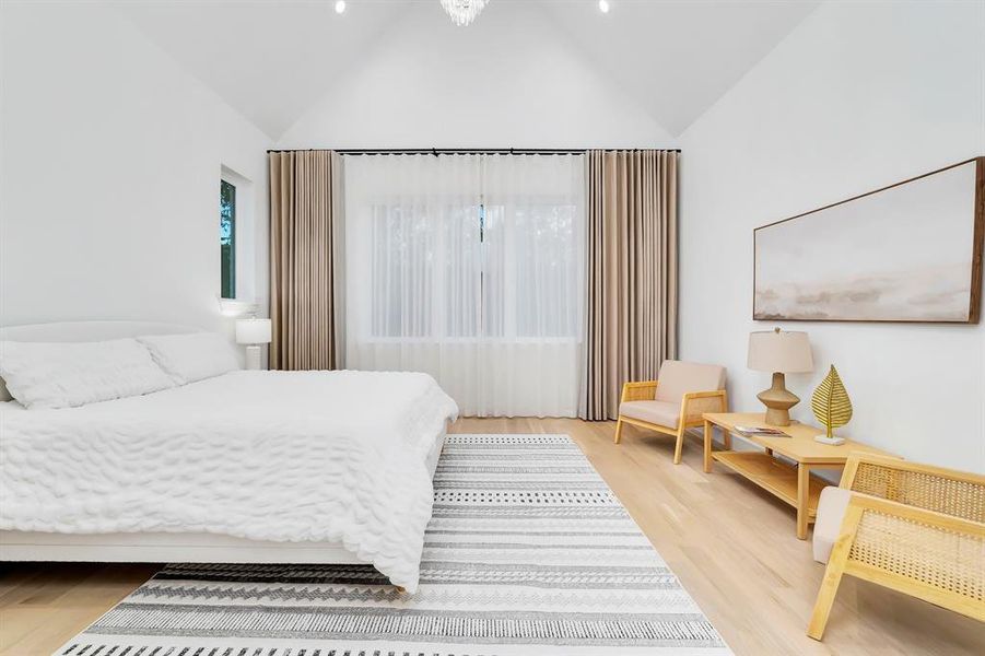 Bedroom with light wood-type flooring and lofted ceiling Bedroom with light wood-type flooring and lofted ceiling