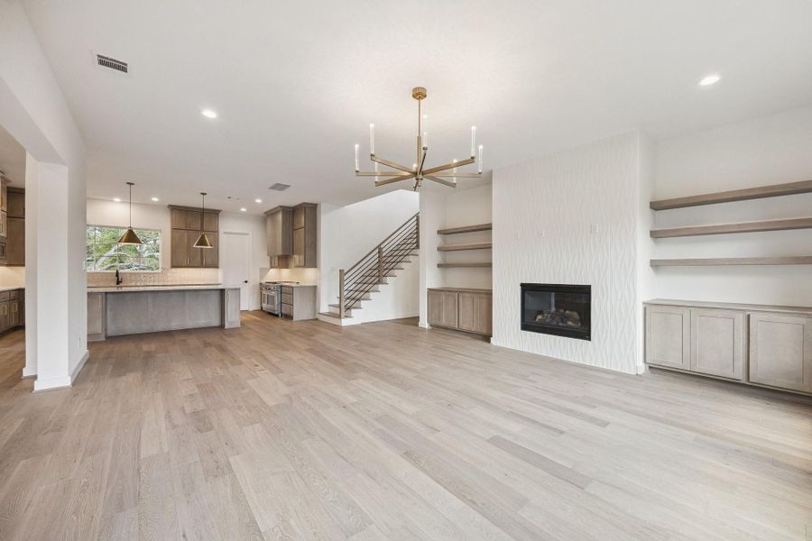 The gas fireplace with large format tile surround, warm tone wood cabinetry and open display shelving creates a focal point and lends character to the space. The gas fireplace with large format tile surround, warm tone wood cabinetry and open display shelving creates a focal point and lends character to the space.