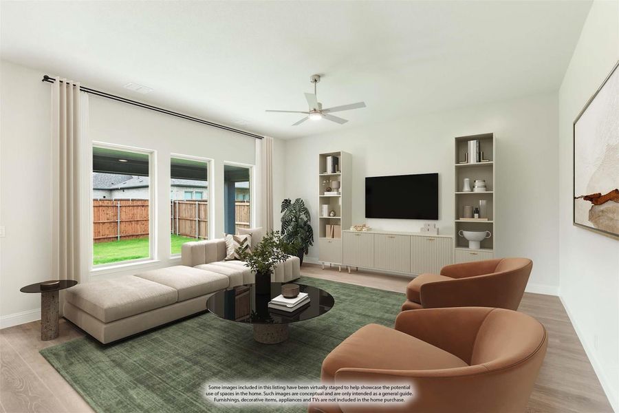 Living room with sectional sofa, built-in shelving, ceiling fan, and large windows overlooking backyard Living room with sectional sofa, built-in shelving, ceiling fan, and large windows overlooking backyard