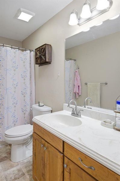 Bathroom vanity featuring a light-toned countertop, wood-finish cabinetry, and a chrome faucet