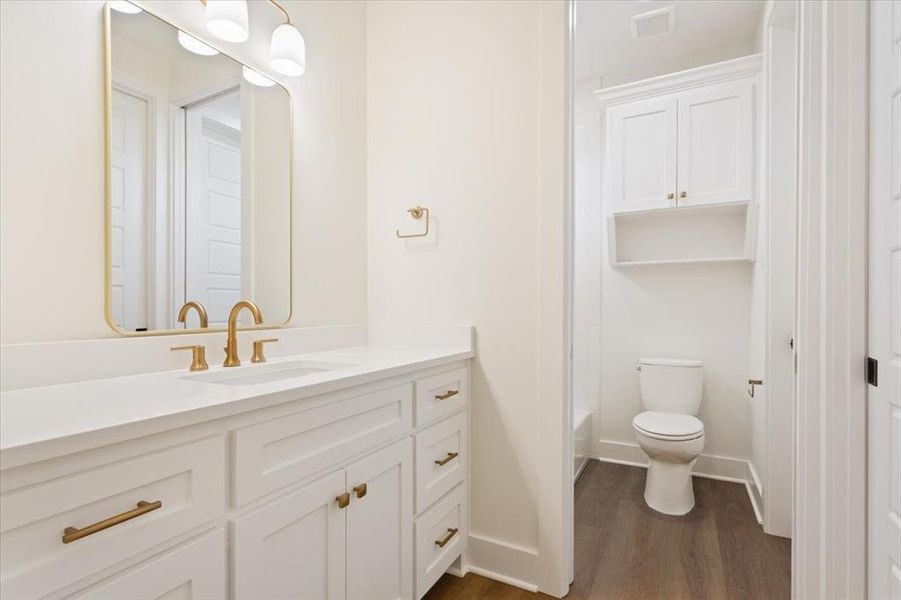 Full bathroom with vanity, dark wood-style flooring, and shower / tub combination