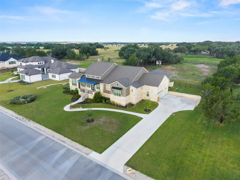 A spacious dwelling with a stone facade sits gracefully amidst well-maintained lawns and a sprawling concrete driveway. A spacious dwelling with a stone facade sits gracefully amidst well-maintained lawns and a sprawling concrete driveway.