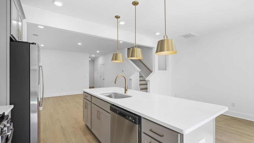 Highly skilled kitchen design includes a 9-foot island, quartz countertops, and stylish pendant fixtures Highly skilled kitchen design includes a 9-foot island, quartz countertops, and stylish pendant fixtures