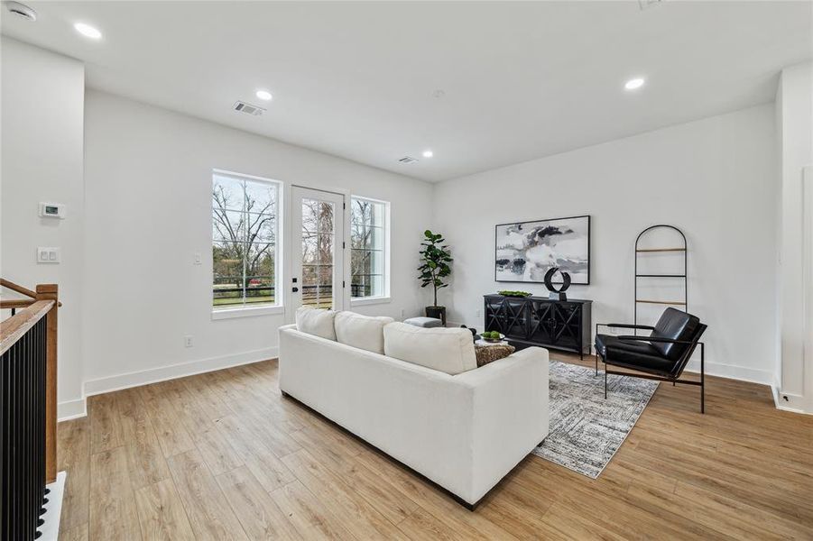 Discover a bright and inviting living space featuring elegant hardwood floors, large windows for abundant natural light, and a modern, open layout perfect for relaxation and entertaining.