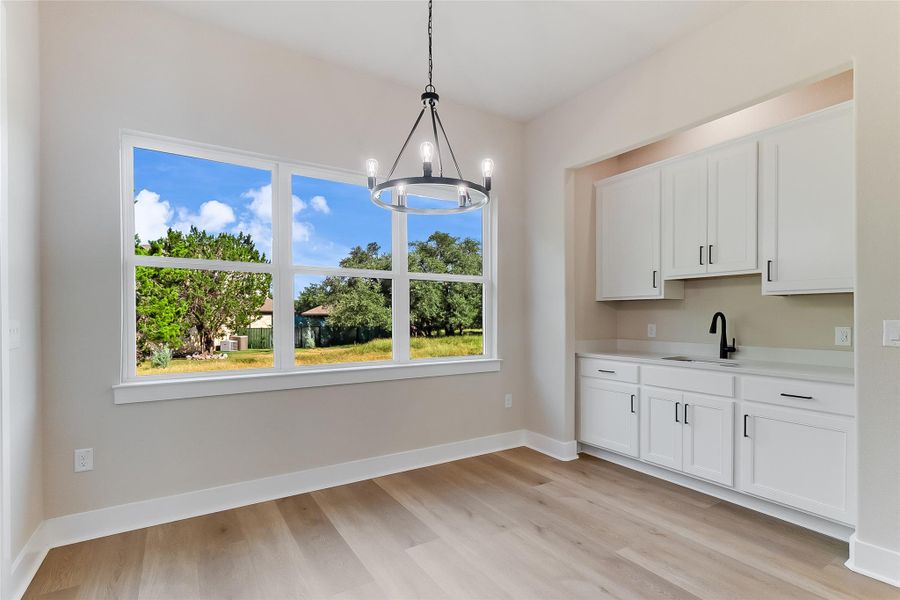 Unfurnished dining area featuring a chandelier and light wood finished floors Unfurnished dining area featuring a chandelier and light wood finished floors