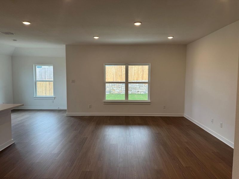 Empty room featuring healthy amount of natural light, recessed lighting, and dark wood-style floors Empty room featuring healthy amount of natural light, recessed lighting, and dark wood-style floors