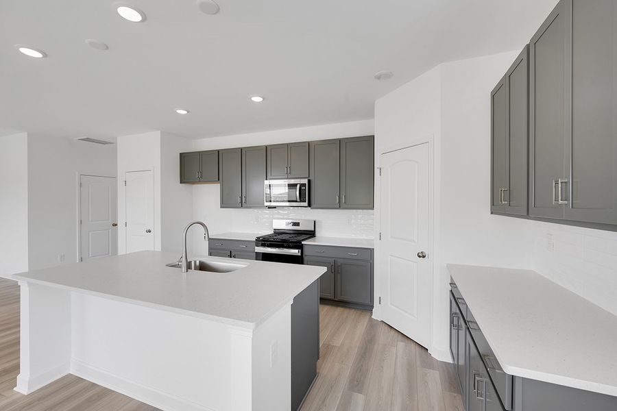 A kitchen with white cabinets.