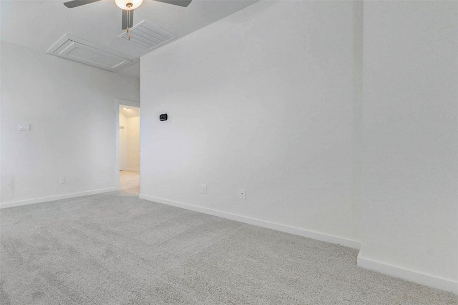 Spacious secondary bedroom with soft carpet, neutral walls, ceiling fan, and a clean open layout ready for personal style. The room offers flexibility for a guest suite, child’s room, office, or hobby space, with easy access to the hallway and a bright, comfortable feel.