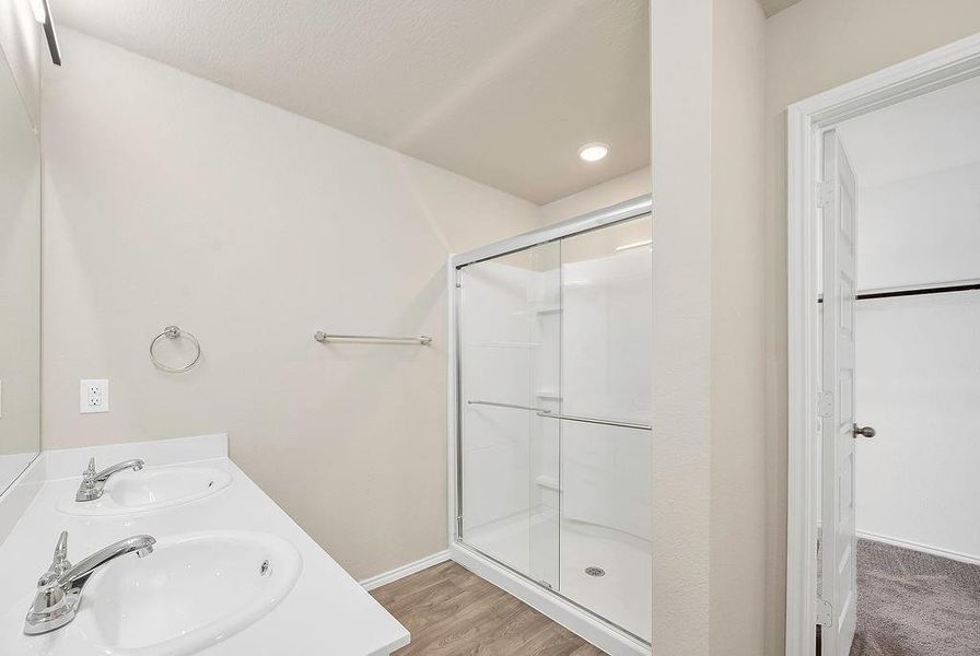 Bathroom featuring vanity, hardwood / wood-style flooring, and walk in shower