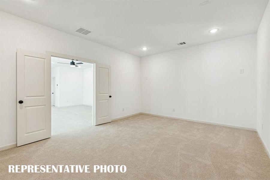 The spacious media room with adjacent game room create the ultimate family entertainment zone!  REPRESENTATIVE PHOTO