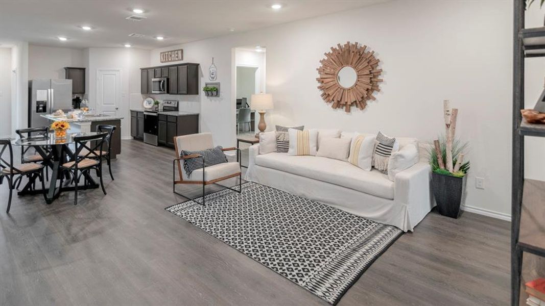 Open-concept living space featuring wood-finish flooring, recessed lighting, and white walls Open-concept living space featuring wood-finish flooring, recessed lighting, and white walls