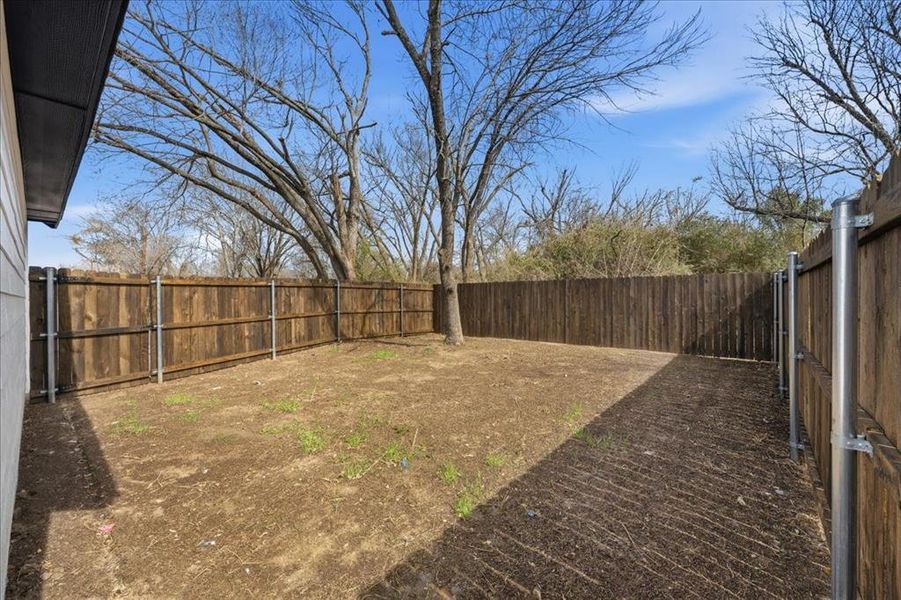 Spacious, fully fenced backyard with mature trees and plenty of room for outdoor living, pets, or play. Detached garage adds additional storage and functionality.