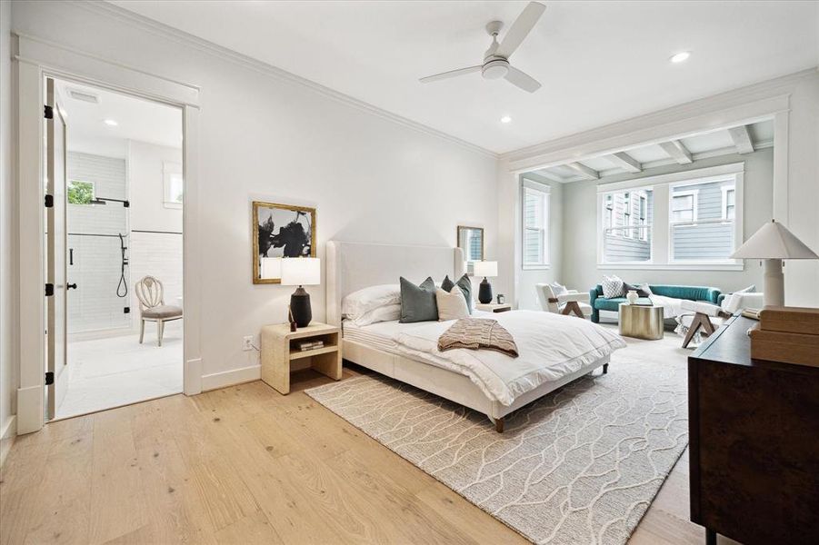 The spacious primary bedroom is quite the retreat with white oak engineered floors, recessed lighting, modern ceiling fan and a relaxing sitting area.